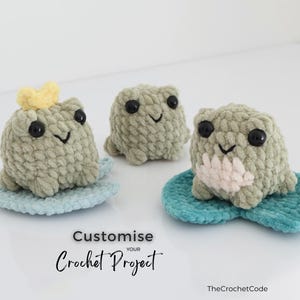 May include: Three handmade crochet frog plushies in shades of green, each with black eyes and a smiling face. One frog wears a yellow crown. They sit on blue lily pads. The text "Customize your Crochet Project" is visible.