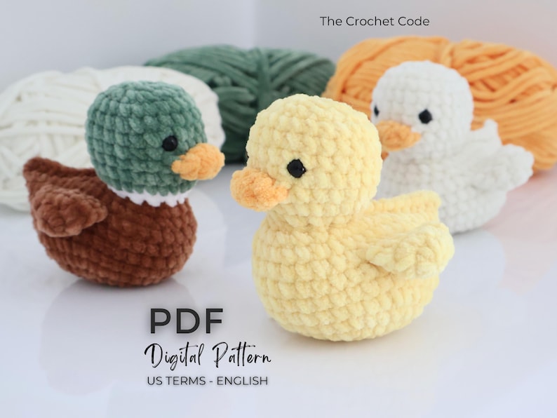 May include: Crocheted ducklings in brown, yellow, and white, with orange beaks and black eyes. The image includes the text "The Crochet Code" and "PDF Digital Pattern US Terms - English". The ducks are set against a backdrop of yarn.