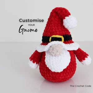 Puede incluir: Un gnomo rojo hecho a mano con barba blanca, ribete de sombrero y pomp&oacute;n. El gnomo tiene un cintur&oacute;n negro con hebilla dorada. El texto "Customise your Gnome" est&aacute; encima del gnomo.