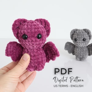 K&ouml;nnte beinhalten: Zwei geh&auml;kelte Fledermaus-Pl&uuml;schtiere, eine in tiefem Lila und die andere in Grau, mit schwarzen Sicherheitsaugen und ausgebreiteten Fl&uuml;geln. Der Text "PDF Digital Pattern US TERMS - ENGLISH" wird angezeigt.
