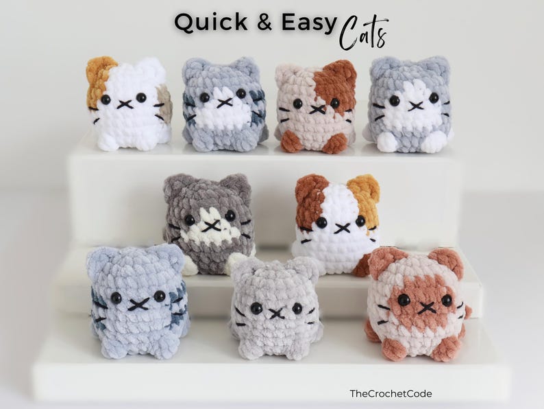 May include: A collection of handmade crochet cat figurines in various colors, including white, gray, brown, and tan. Each cat has a unique pattern and embroidered facial features. The text "Quick & Easy Cats" is displayed at the top.