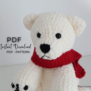May include: A handmade white crochet polar bear with a red scarf. The bear has black eyes and a black nose. The text "PDF Instant Download PDF - PATTERN" is in the upper left corner. The Crochet Code is in the lower right corner.