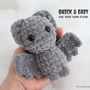 May include: A gray crocheted bat plush toy with black eyes. The toy is being held in a person's hand. The text "QUICK & EASY USE YOUR YARN STASH" is above the toy. The text "The Crochet Code" is below the toy.