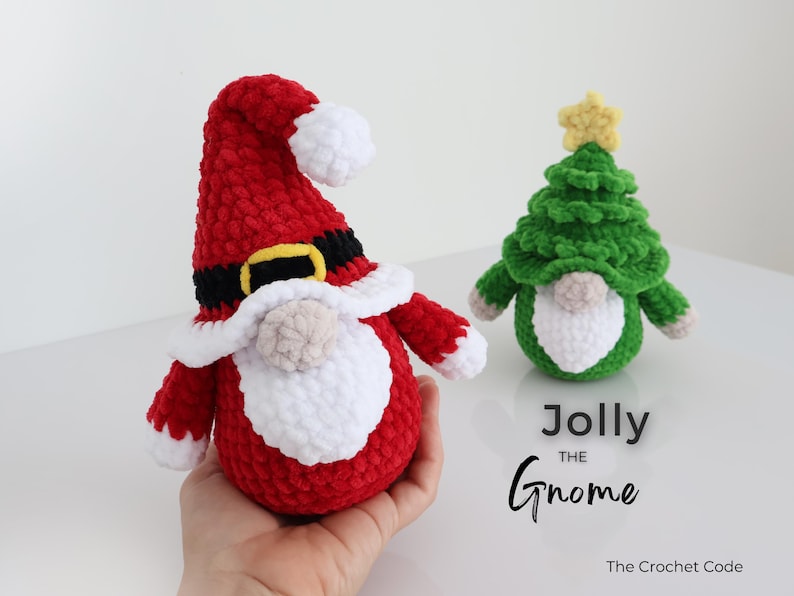 Puede incluir: Dos gnomos de ganchillo hechos a mano. Uno es rojo con barba y gorro blancos, cintur&oacute;n negro y hebilla amarilla. El otro es verde, con forma de &aacute;rbol de Navidad, con una estrella amarilla. El texto dice "Jolly the Gnome."