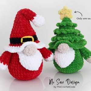 Puede incluir: Dos gnomos navide&ntilde;os de peluche. Uno es rojo con barba y gorro blancos, que se asemeja a Pap&aacute; Noel. El otro es verde, con forma de &aacute;rbol de Navidad, con una estrella amarilla en la parte superior. Los gnomos est&aacute;n hechos a mano y son parte de una colecci&oacute;n navide&ntilde;a.
