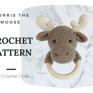 Peut inclure: Patron de crochet pour un hochet en forme d'élan brun avec un anneau en bois. Le patron s'appelle "Morris the Moose" et est de The Crochet Code.