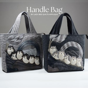 Peut inclure: Deux sacs cabas matelassés avec des appliques de hiboux. Le sac de gauche est gris avec un motif de hibou gris clair. Le sac de droite est gris foncé avec un motif de hibou noir. Les deux sacs portent l'inscription "Handle Bag by Lady Bee Quilts Applique" imprimée sur le devant.