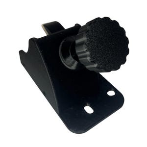 May include: A black, 3D-printed bracket with a textured knob. The bracket has a curved design with two circular holes and a small hook. The knob is round with a ridged edge.