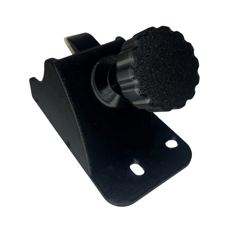 May include: A black, 3D-printed bracket with a textured knob. The bracket has a curved design with two circular holes and a small hook. The knob is round with a ridged edge.