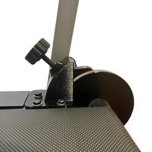 May include: Close-up of a black adjustable clamp with a textured surface. The clamp features a black knob and is attached to a gray pole and a black, circular component. The background is white.