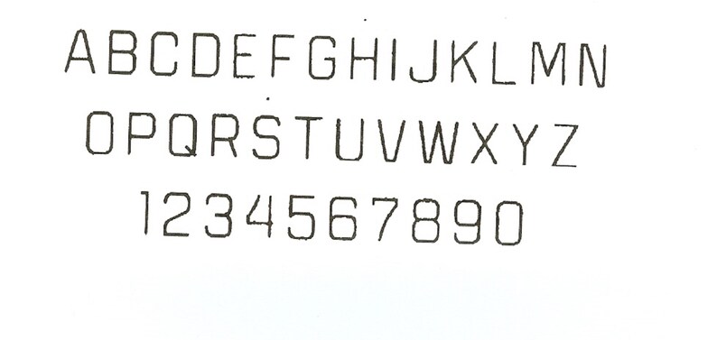 May include: A black and white image of the alphabet in uppercase letters, followed by the numbers 1 through 9 and 0.