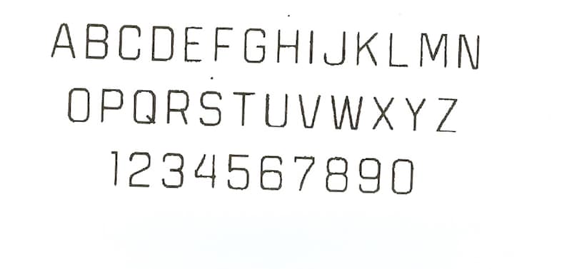 May include: A white background displays the alphabet from A to Z and numbers 1 through 0. The letters and numbers are in a sans-serif font, with a slightly slanted design. The characters are black.