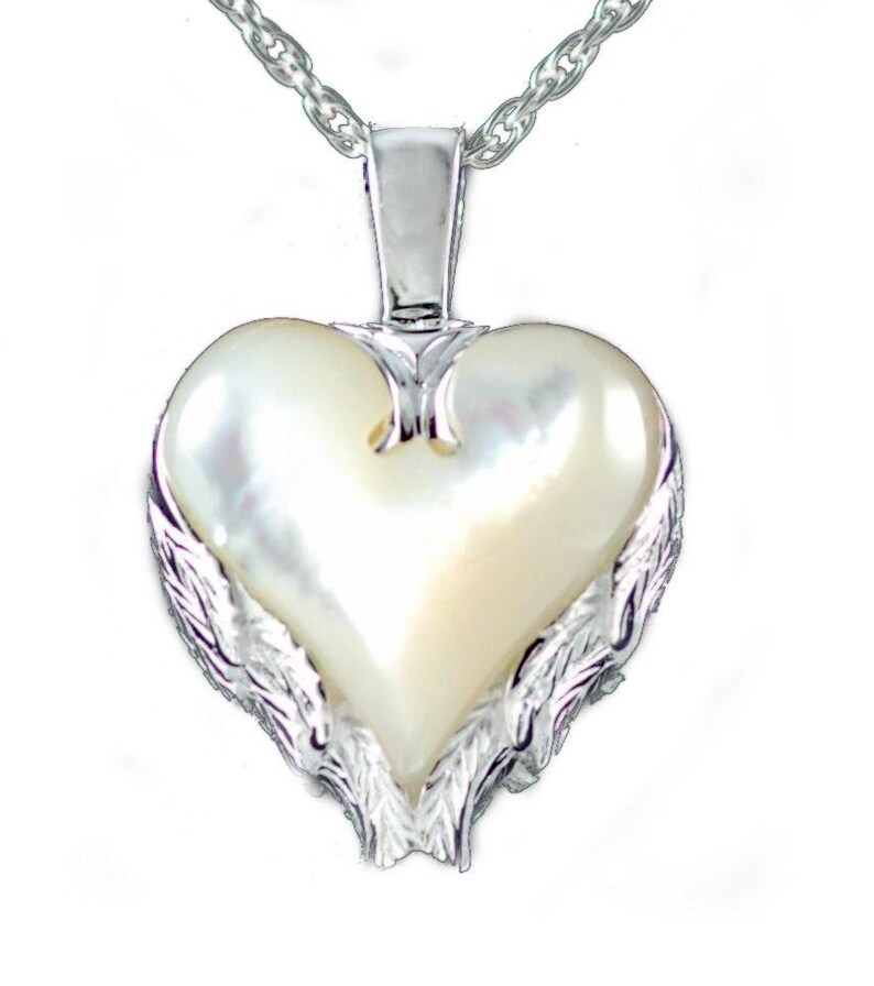 May include: A heart-shaped pendant with a pearlescent center and silver-colored wing accents. The pendant hangs from a silver chain. The heart-shaped pendant is a romantic jewelry item.