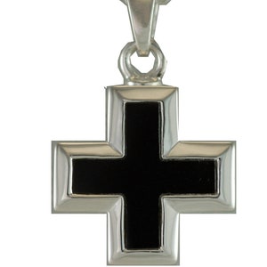 May include: A silver pendant in the shape of a cross with a black onyx center.