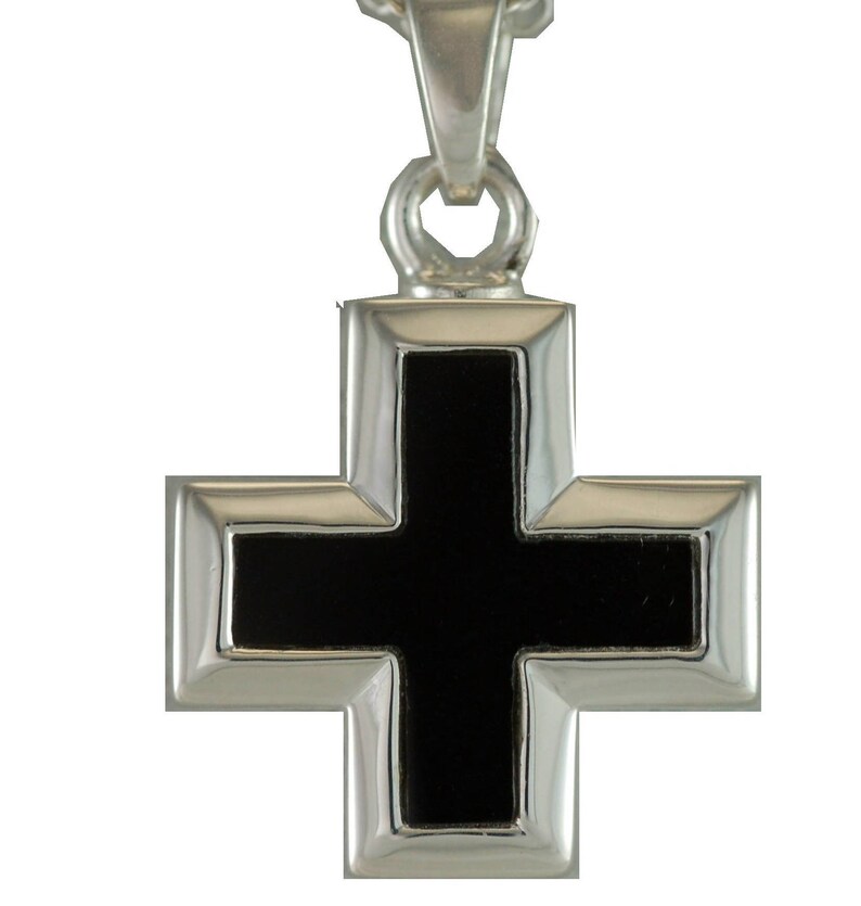 May include: A silver pendant in the shape of a cross with a black onyx center.