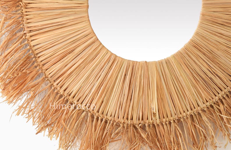 Pu&ograve; includere: Uno specchio da parete rotondo con una cornice in paglia intrecciata. La cornice &egrave; realizzata in paglia color naturale, disposta a raggiera con un bordo sfrangiato. Il design &egrave; semplice e rustico, adatto a vari stili di interni.