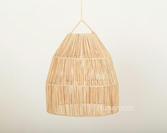 May include: A natural woven pendant light fixture. The light fixture is cone-shaped, made of light brown woven material, and suspended from a single cord. The fixture is designed to hang from the ceiling and provide ambient lighting.