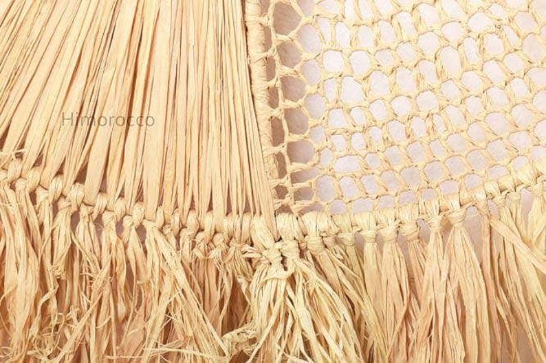 K&ouml;nnte beinhalten: Nahaufnahme einer gewebten Makramee-Wandbeh&auml;nge mit Fransenrand. Die Beh&auml;nge ist aus Naturfasern gefertigt und hat eine hellbeige Farbe.