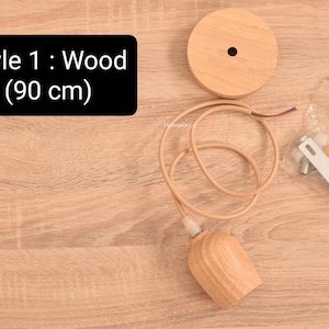 K&ouml;nnte beinhalten: Holz-Pendelleuchte mit hellbraunem Finish. Die Leuchte umfasst eine Deckenplatte aus Holz, ein Kabel und einen Lampenhalter aus Holz. Der Text auf dem Bild lautet "Style 1: Wood (90 cm)". Montagematerial ist ebenfalls enthalten.