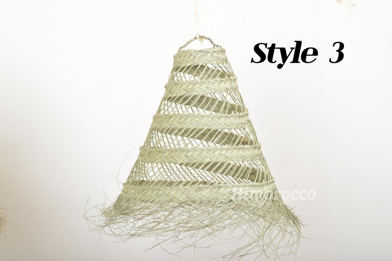 May include: A woven, light beige, cone-shaped lampshade with a fringe trim. The lampshade is labeled "Style 3".