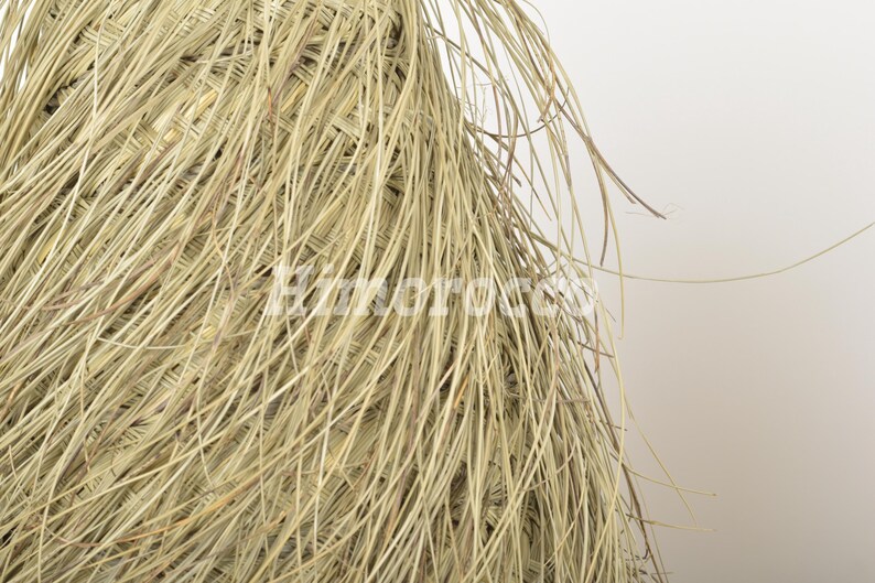 May include: Close-up of a woven basket made from natural fibers, with a light brown color and a rough texture.