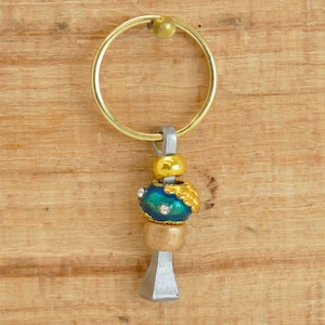 Op de afbeelding: Een gouden hoefijzerbedel met een blauwe en gouden kraal en een gouden ring.