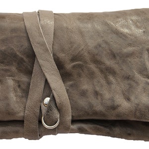 May include: A gray leather tobacco pouch with a strap closure and a silver metal ring. A green lighter is next to the pouch.