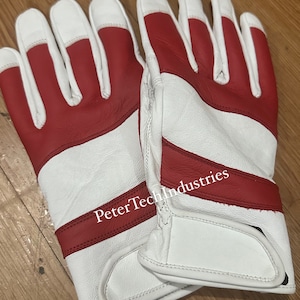 Op de afbeelding: Een paar witte leren handschoenen met rode accenten. De handschoenen hebben een rode streep over de rug van de hand en een rode band om de pols. De tekst "PeterTechIndustries" is gedrukt op de rode band.