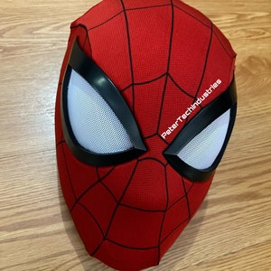 May include: Red and black Spider-Man mask with a white mesh eye piece. The mask has the text "PeterTechIndustries" printed on the side.