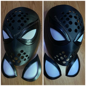 May include: Black and white Spider-Man mask with a textured surface and a mesh design. The mask is made of plastic and has a hole in the front. The mask is accompanied by three separate eye pieces.