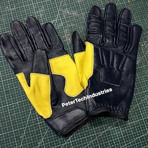 May include: A pair of black leather gloves with yellow accents. The gloves have a textured design and the text "PeterTechIndustries" is visible on the back of one glove.