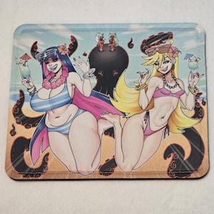 Może przedstawiać: Prostokątna podkładka pod mysz z kreskówkową ilustracją dwóch kobiet w bikini na plaży, z ośmiornicą i innymi postaciami. Czarna mysz do gier znajduje się po prawej stronie podkładki.