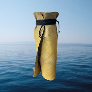 Puede incluir: Una bolsa de botella tejida de color amarillo con un cordón de cierre negro. La bolsa está colgando sobre un fondo de agua azul.