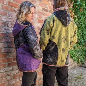 Peut inclure: Deux personnes portant des vestes à capuche avec des motifs de patchwork colorés. Les vestes présentent une variété de motifs et de couleurs, notamment le violet, le vert, le noir et le jaune. Les vestes sont faites d'un tissu doux et confortable et ont une coupe décontractée.
