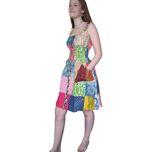 May include: A patchwork dress featuring a mix of colourful floral and geometric patterns. The dress has a fitted bodice and a flowing skirt.