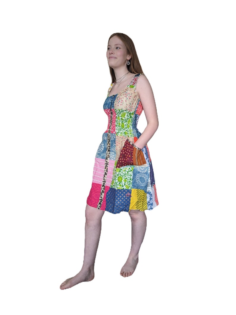 May include: A patchwork dress with a variety of colorful floral and geometric patterns. The dress has a fitted bodice and a flowy skirt.