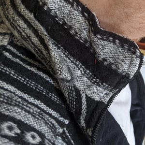 K&ouml;nnte beinhalten: Schwarz-wei&szlig;e gemusterte Jacke mit Rei&szlig;verschluss. Die Jacke hat ein Fleecefutter.