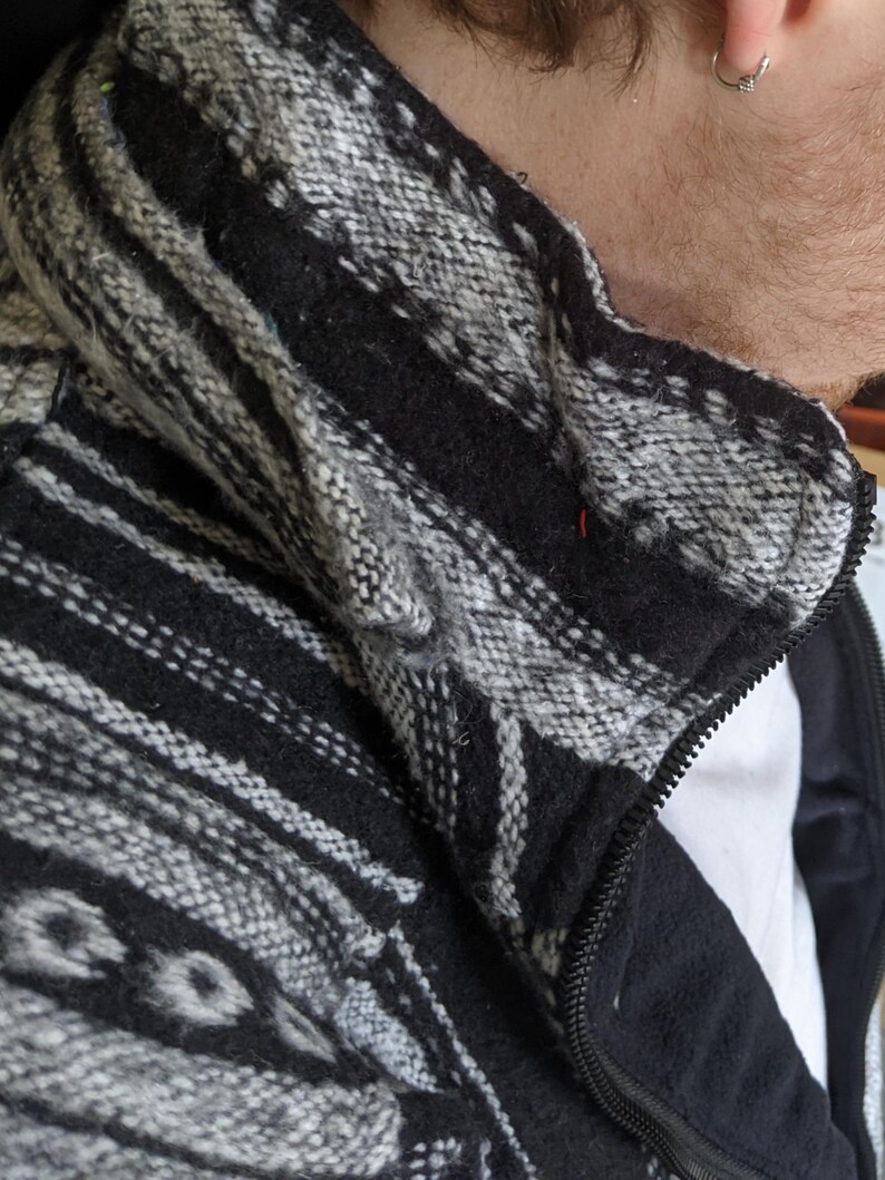 K&ouml;nnte beinhalten: Schwarz-wei&szlig;e gemusterte Jacke mit Rei&szlig;verschluss. Die Jacke hat ein Fleecefutter.