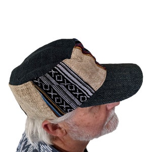 Peut inclure: Une casquette de baseball à visière incurvée avec un motif noir et beige. La casquette est faite d'un tissu tissé et présente un design en patchwork.