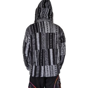 K&ouml;nnte beinhalten: Schwarze und wei&szlig;e Kapuzenjacke mit geometrischem Muster. Die Jacke ist aus weichem, gewebtem Stoff und hat eine lockere Passform.