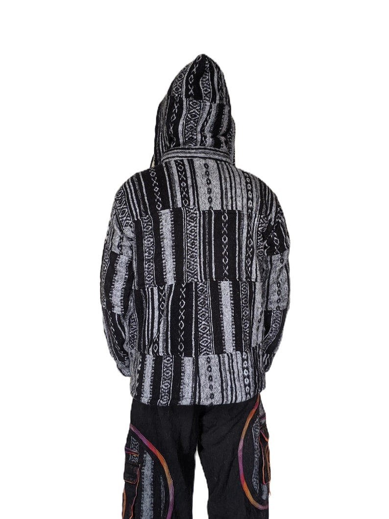 K&ouml;nnte beinhalten: Schwarze und wei&szlig;e Kapuzenjacke mit geometrischem Muster. Die Jacke ist aus weichem, gewebtem Stoff und hat eine lockere Passform.