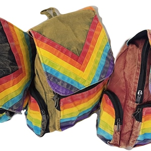 May include: Three canvas backpacks with rainbow chevron and stripe designs. The backpacks are in different colors: black, brown, and red.