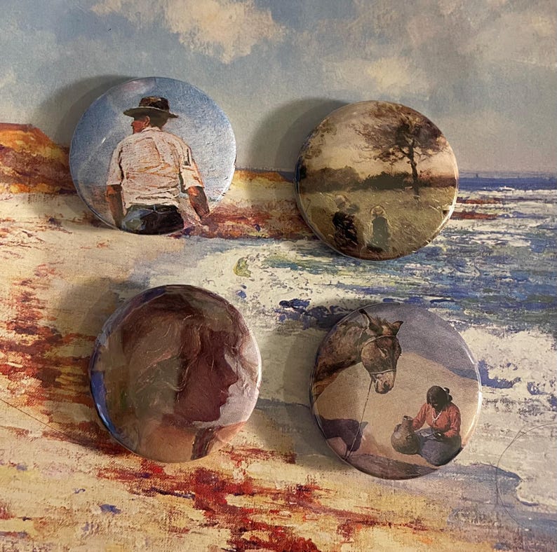 May include: Four round button badges featuring different images. The first badge depicts a man in a hat and a white shirt standing on a beach. The second badge shows a landscape with a tree in the background. The third badge has a painting of a woman's face. The fourth badge shows a woman sitting on the ground with a donkey standing nearby.