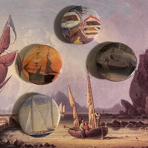 May include: Four round buttons featuring images of sailing ships. The buttons are displayed against a backdrop of a painting depicting a seascape with a sailboat in the foreground.