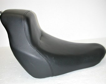 May include: Black leather motorcycle seat with a contoured design.