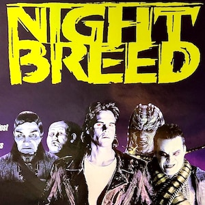 Könnte beinhalten: Ein Filmplakat für "Nightbreed" mit einem dunklen, gotischen Thema, das eine Gruppe von Charakteren zeigt. Der Titel ist in großen, gelben, stilisierten Buchstaben gehalten. Das Plakat enthält die Namen der Schauspieler und der Crew sowie Zitate aus verschiedenen Publikationen.