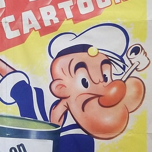 May include: A vintage poster advertising a new Popeye cartoon titled "Nix on Hypnotricks". The poster features a cartoon image of Popeye holding a can of spinach with an anchor on it. The poster is yellow with red and blue accents.