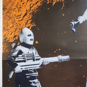 Puede incluir: Una imagen en blanco y negro de un soldado futurista que lleva un casco blanco con una visera negra y sostiene un arma futurista grande. El soldado está de pie frente a un fondo oscuro con motas de color naranja y blanco.