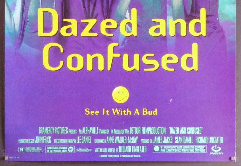 Może przedstawiać: Plakat filmu "Dazed and Confused" z ż&oacute;łtym napisem na fioletowym tle. Plakat zawiera frazę "See It With A Bud" i uśmiechniętą buźkę.