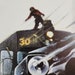 May include: A black and silver train engine with a large headlight and a number "30" on the side. A red figure is standing on top of the engine.